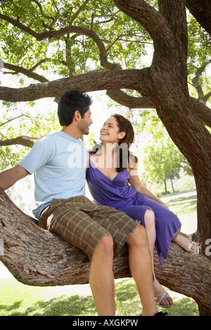 Giovane seduto nella struttura ad albero Foto Stock