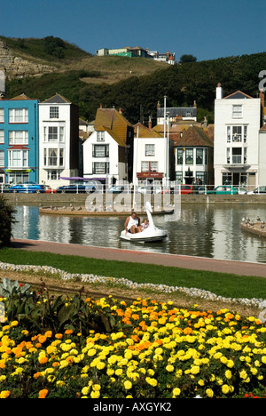 Fiori e gite in barca sul lago West Hill sullo sfondo le Stade parco dei divertimenti di Hastings Old Town East Sussex Foto Stock