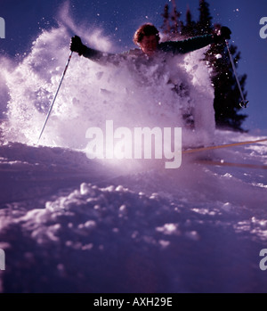 Sciatore lo scoppio attraverso la polvere di neve crea una nuvola di fiocchi nella sua scia a Sun Valley Resort in Idaho Foto Stock