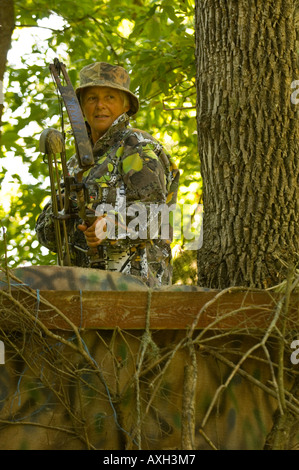 La donna nel supporto albero caccia coda bianca cervo con bow NORTH CENTRAL MINNESOTA Foto Stock