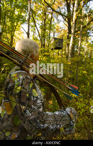 Donna BOW HUNTER si accosta al suo stand di cervi nei boschi NORTH CENTRAL MINNESOTA Foto Stock