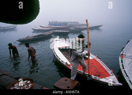 Gli indù la balneazione e le barche di preparare per i visitatori vogliono mettere il desiderio candele sul Gange Varanasi India Foto Stock