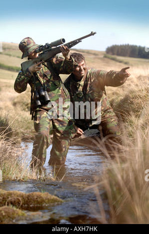 Un esercito britannico femmina sotto istruzione dauno sergente di colore su di una levetta di formazione durante un corso di cecchino in Brecon Galles Wales Foto Stock