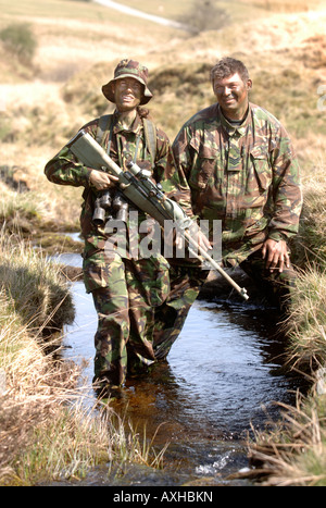 Un esercito britannico femmina sotto istruzione da un sergente di colore su di una levetta di formazione durante un corso di cecchino in Brecon Galles Wales Foto Stock