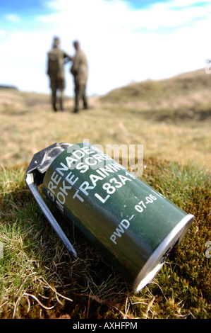 Un esercito britannico reclutare femmina tenendo istruzione da un colore sergente istruttore con un usato cortina di fumo granata nel FOREG Foto Stock
