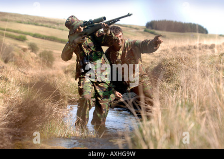 Un esercito britannico femmina sotto istruzione dauno sergente di colore su di una levetta di formazione durante un corso di cecchino in Brecon Galles Wales Foto Stock