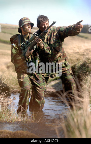 Un esercito britannico femmina sotto istruzione dauno sergente di colore su di una levetta di formazione durante un corso di cecchino in Brecon Galles Wales Foto Stock