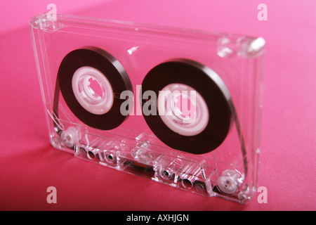 Audio trasparente cassetta a nastro su un sfondo rosa. Foto Stock