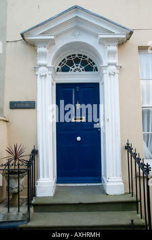 Ornati in Regency era blu scuro porte dipinte di bianco porte dipinte caso in Tenby Pembrokeshire Wales UK Foto Stock