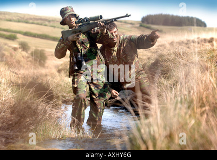 Un esercito britannico femmina sotto istruzione dauno sergente di colore su di una levetta di formazione durante un corso di cecchino in Brecon Galles Wales Foto Stock