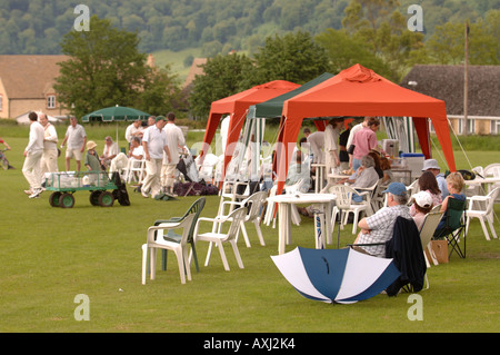 Il Cricketers emergono dalle tende dopo si ripara dalla pioggia durante una partita di villaggio GLOUCESTERSHIRE REGNO UNITO Foto Stock