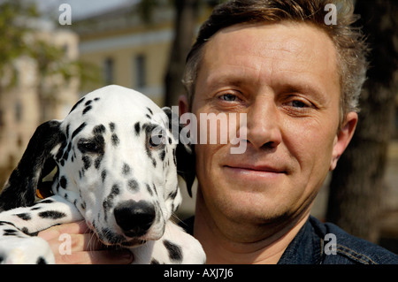 Uomo e un giovane cane dalmata Foto Stock