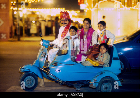 La famiglia indiana che si aggirava su un piccolo scooter a motore che festeggia di notte durante il festival di Diwali a Jaipur Rajasthan, India Foto Stock