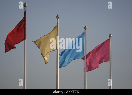 Fila di bandiere colorate battenti su pali Foto Stock