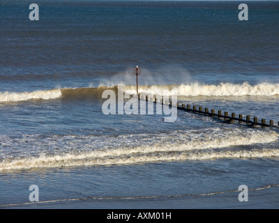 Rottura d'onda su un groyne sulla spiaggia di Aberdeen Foto Stock