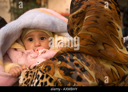 Donna libico portando il suo bambino nella Medina o Città Vecchia Tripoli in Libia Foto Stock