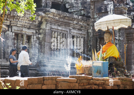 Uomo e donna che prega alla statua del Buddha, Wat Phu Foto Stock