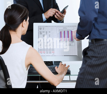 Imprenditori e intorno al computer con il grafico su schermo Foto Stock