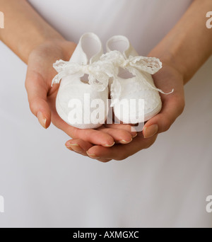 Close up della donna azienda scarpe per bambini Foto Stock