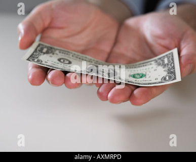 Le mani sono in possesso di un dollaro americano Bill Foto Stock
