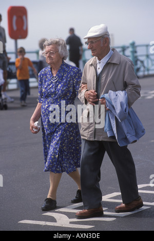 Anziani pensionati di vecchiaia che camminano sul lungomare. Un paio, marito e moglie braccio in braccio. Brighton East Sussex Inghilterra Regno Unito 2000s 2001 HOMER SYKES Foto Stock