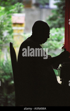 Il Vietnam, Silhouette del monaco seduto alla scrivania Foto Stock