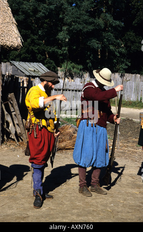 Gli uomini in carattere caricando i loro moschetti a Plymouth Plantation insediamento modello Massachusetts MA USA Foto Stock