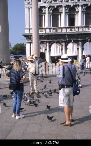 I turisti a Venezia alimentazione dei piccioni nei pressi di Piazza San Marco Foto Stock