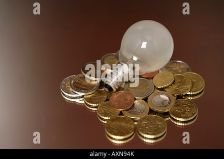 Lampadina elettrica su una pila di Euro-monete, close-up Foto Stock