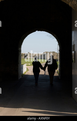 Giovane Holding Hands visita Portchester Castle attraverso il rivellino arcuato 1 di 2 Foto Stock