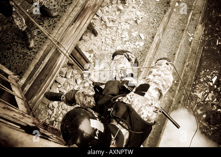 Un anti-terrorismo di soldato è la discesa in corda doppia nel corso di esercitazioni. Una granata di fumo è stato buttato giù per coprire l'azione. Foto Stock