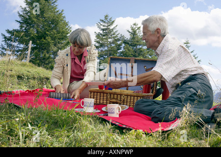 Senior adulto giovane avente un picnic in montagna, il fuoco selettivo Foto Stock