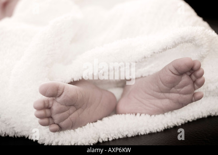 Nuovo nato infantile piedi spuntavano da sotto una coltre bianca Alaska Stati Uniti Causasian Foto Stock