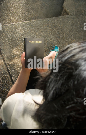 Donna che guarda la Bibbia Foto Stock