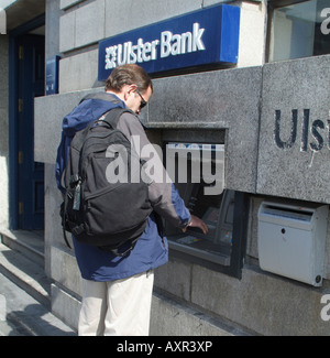 L'uomo utilizzando il foro nella parete Cash dispenser macchina a Ulster Bank a Dublino Foto Stock