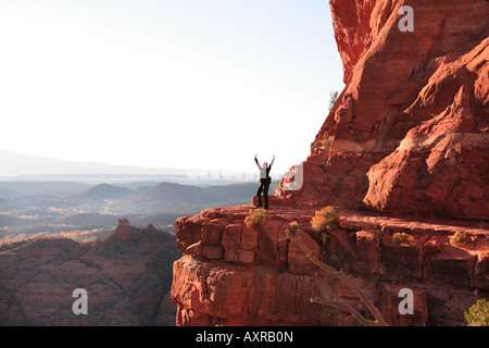 Escursionista femmina su un promontorio roccioso sulla sommità della cattedrale di roccia in Sedona in Arizona USA Foto Stock