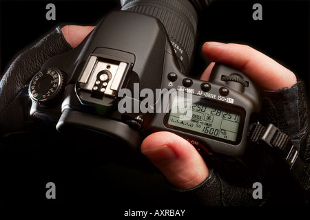 Mani tenendo una fotocamera reflex digitale Foto Stock