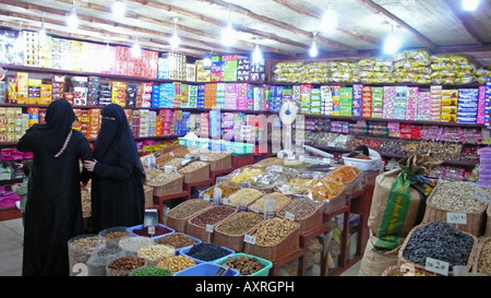 Due donne locali che fanno acquisti in un negozio di alimenti secchi a Souq Waqif, Doha Qatar. Foto Stock