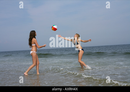 Due giovani donne giocando a pallavolo in spiaggia Foto Stock