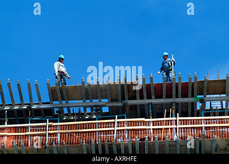 Lavoratore sulla cima di un alto edificio in costruzione Foto Stock