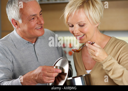 Donna bionda degustazione qualcosa di un colore grigio-uomo dai capelli ha cotto Foto Stock