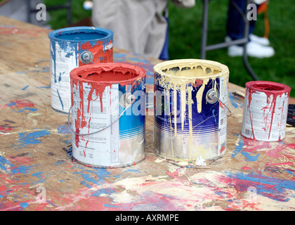 Multi-colore di lattine di vernice su vernice opener tabella Foto Stock