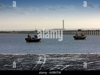 Barche da pesca e Southend Pier in background nella luce della sera Foto Stock