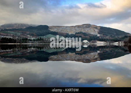 Un riflesso perfetto del paesaggio nelle acque di un scozzese Loch Foto Stock