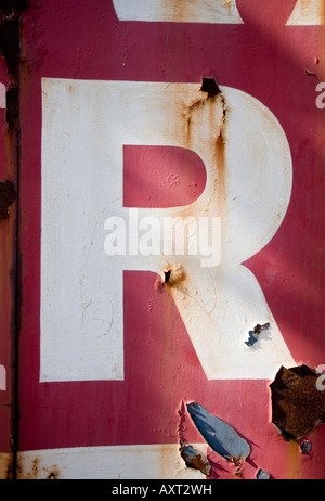 Sbucciare la lettera R sulla ruggine in disuso cantiere di rottami di cancelli. Utilizzare per drop caps con testo, illuminata lettera, monogramma, indicizzazione etc. Foto Stock