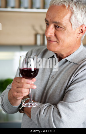 Grigio-dai capelli uomo con un bicchiere di vino in mano, close-up Foto Stock