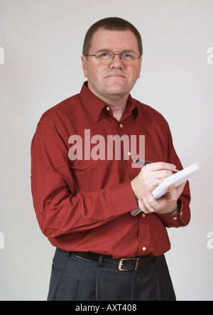 Uomo con notebook e penna che indossa una camicia rossa. Foto Stock