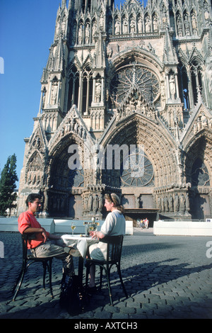 Giovane con champagne nella parte anteriore della cattedrale di Reims nel distretto di champagne di Francia Foto Stock