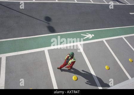 Operaio edile passeggiate lungo inutilizzato parcheggio auto baie esterno aperto recentemente dall'Aeroporto Heathrow di Londra del terminale 5 edificio Foto Stock