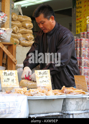 Il venditore è in conclusione di merci su un mercato in Chinatown, USA, Manhatten, Chinatown, New York Foto Stock